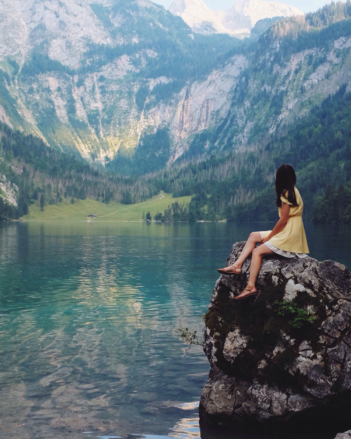 woman on a rock at a mountain lake