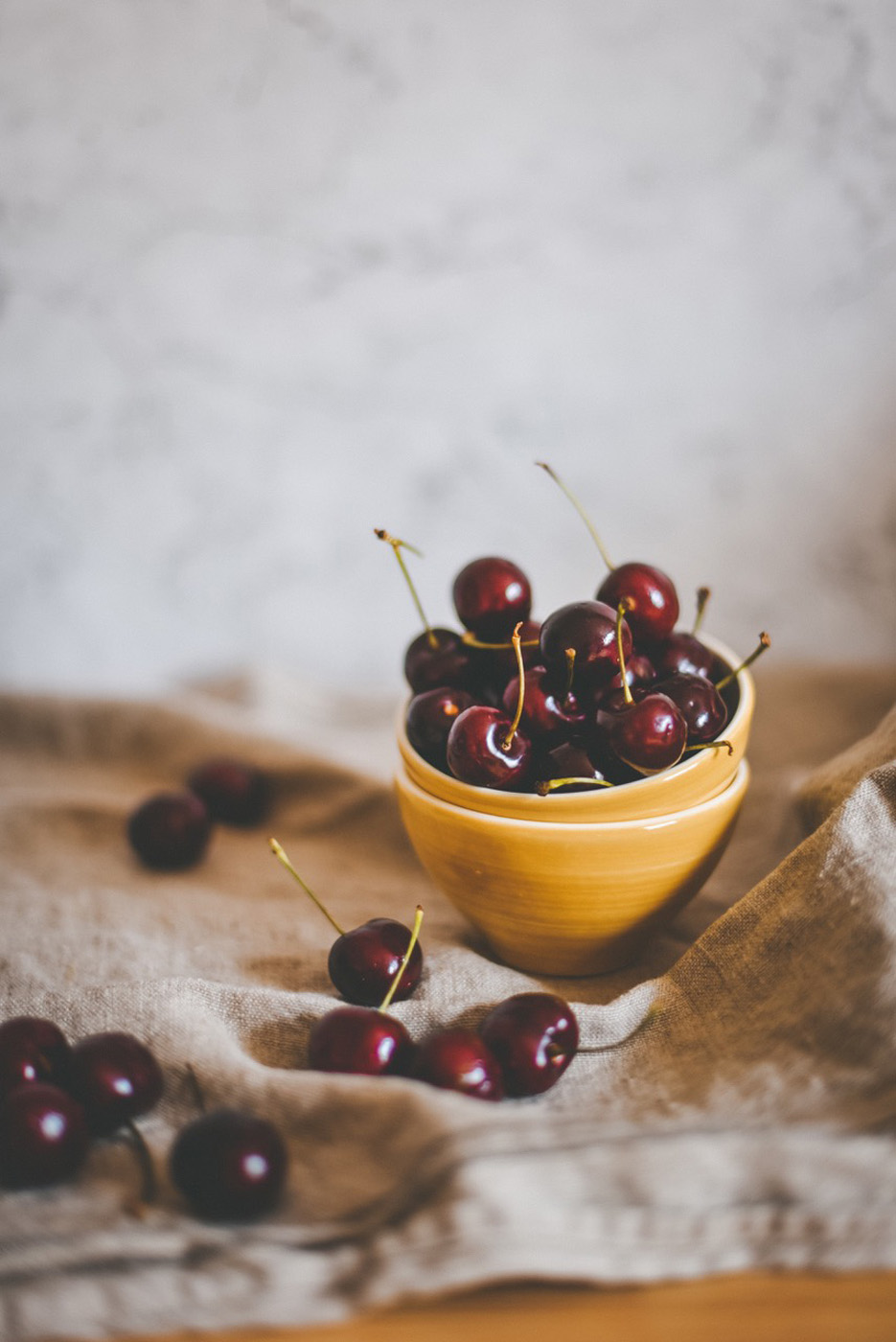 ripe black cherries in a yellow bowl