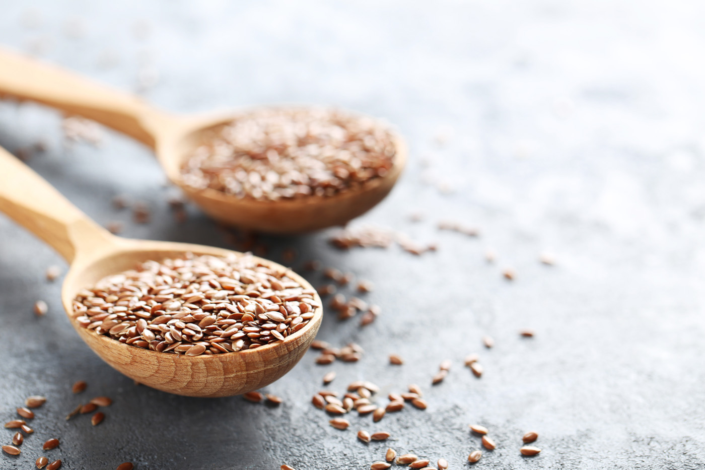 Brown flax seeds on grey wooden table