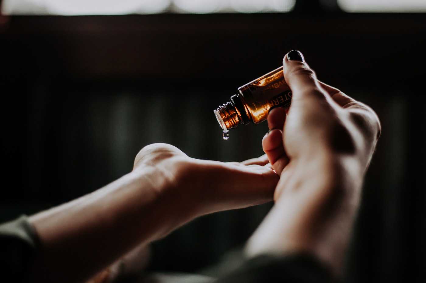 woman pouring massage oil onto her hands