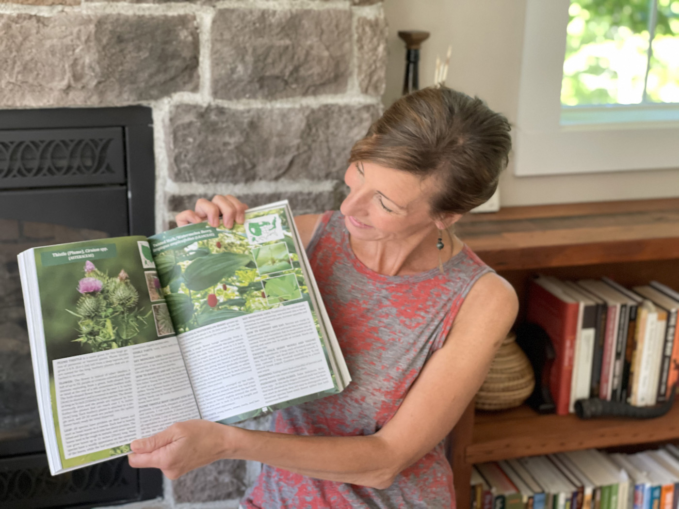 Nicole Apelian holding up a page of her Foraging Guide