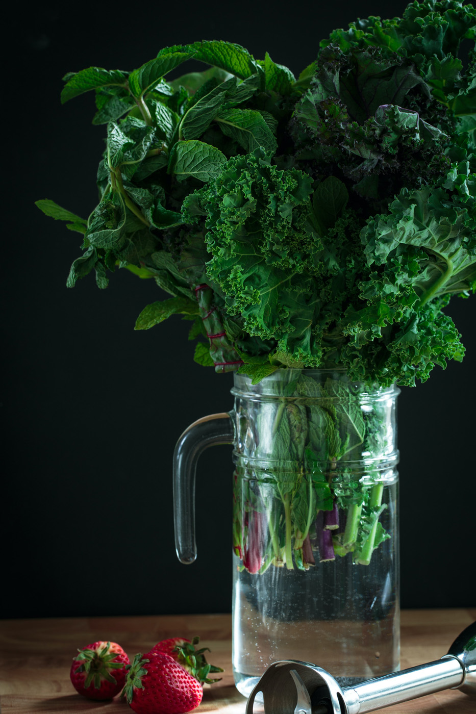 leafy greens kale in glass pitcher with strawberries