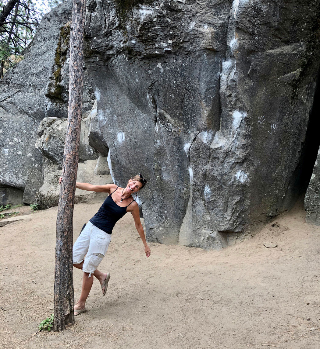 Joyful Nicole Apelian swinging around tree trunk