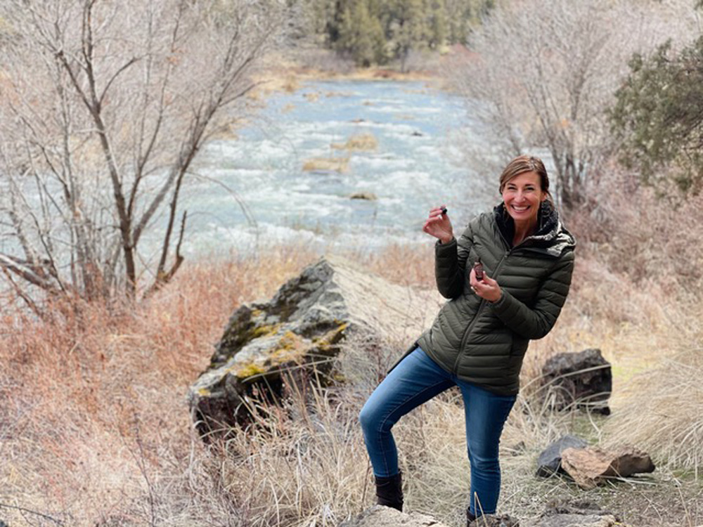 Nicole Apelian holding tincture by the river