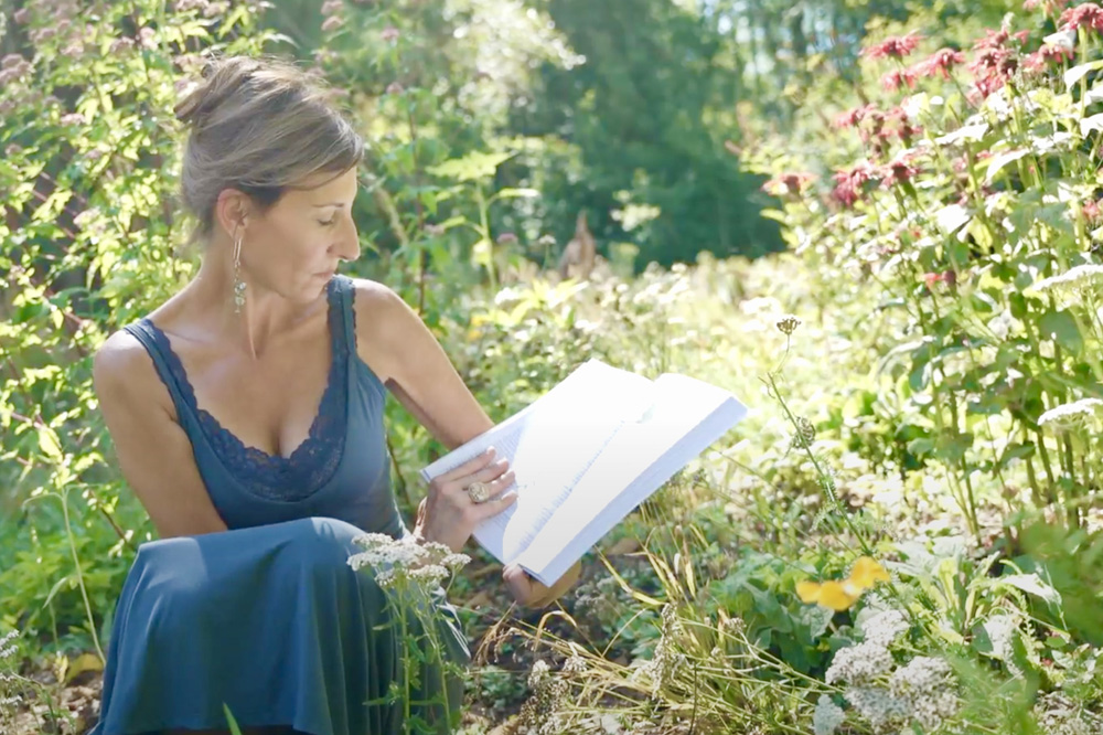 Nicole Apelian in garden with book bee balm
