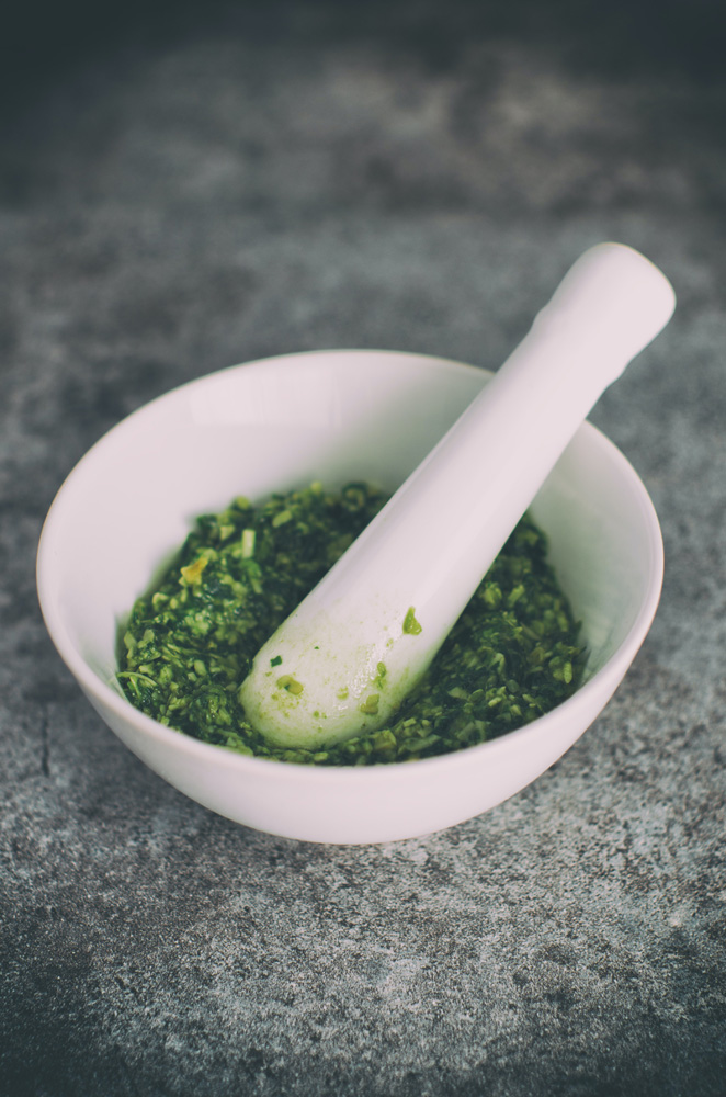 preparing pesto with mortar and pestle