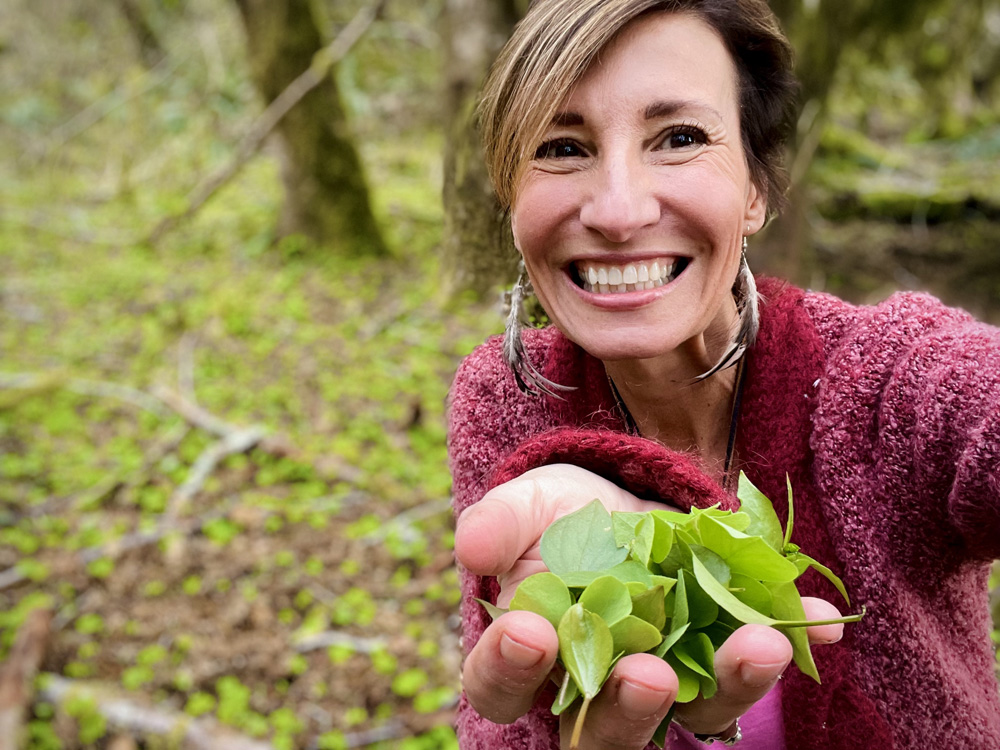 Nicole Apelian holding wild greens foraged food miners lettuce wood sorrel
