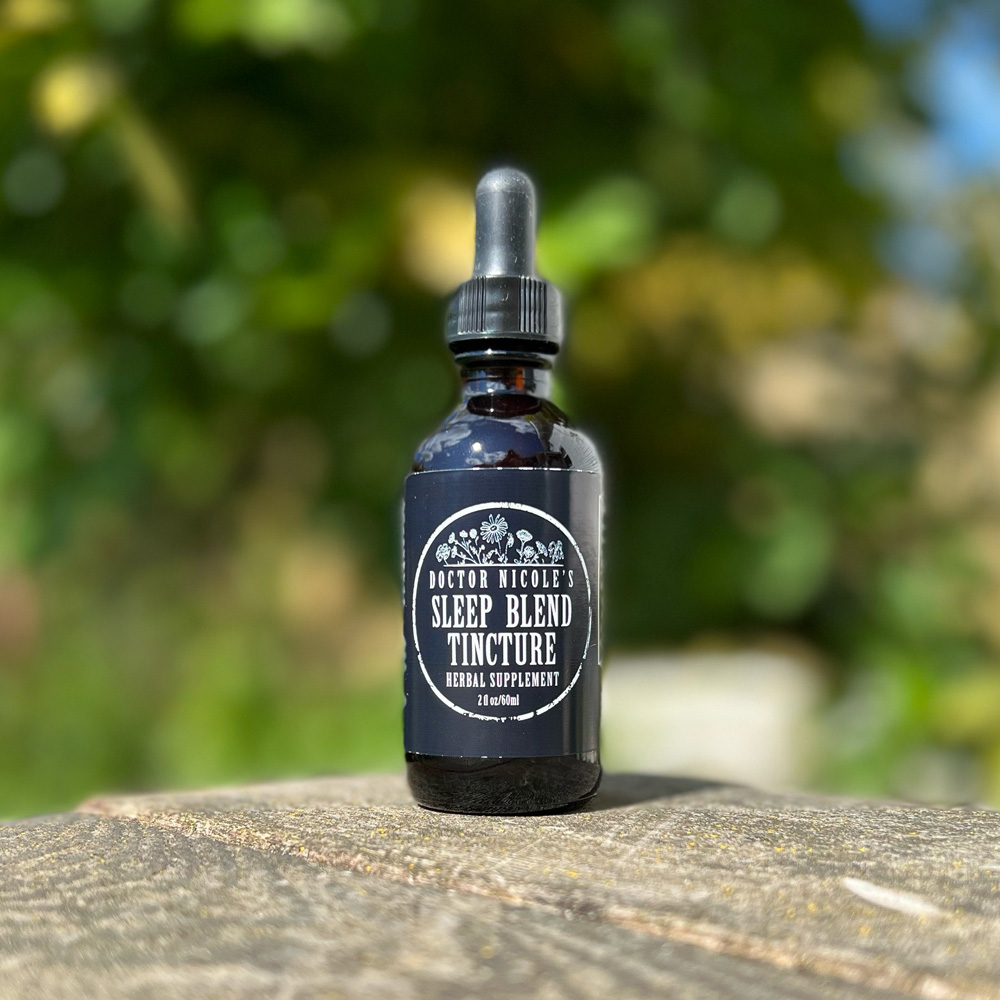 Nicoles Apothecary Sleep Blend Tincture outdoors on rustic table