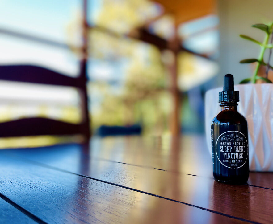 Nicoles Apothecary Bronchial Blend tincture Nicoles Apothecary Sleep Blend Tincture on wood table next to window