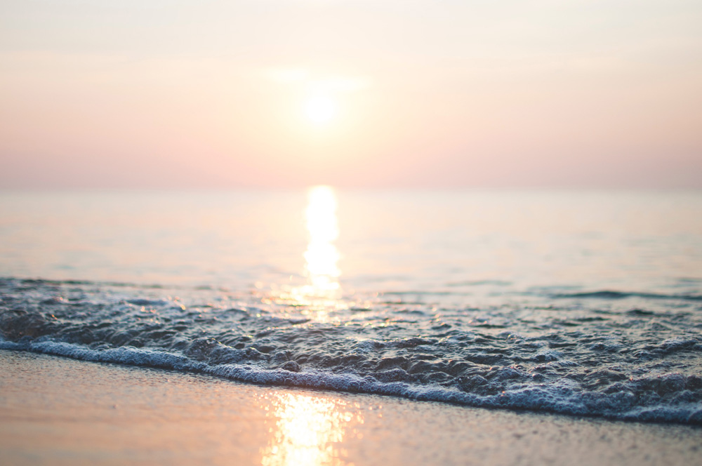 foamy tide on a beach at sunset