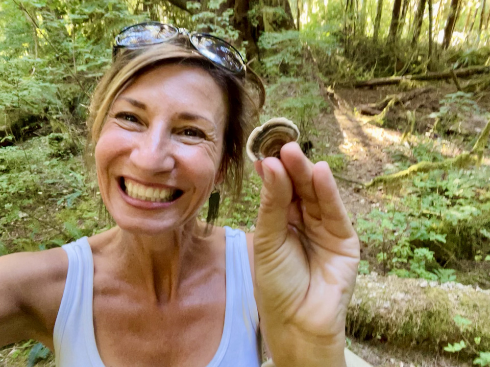 Nicole with Turkey Tail Mushroom outside hiking PNW