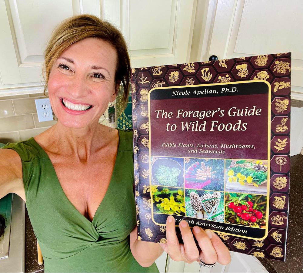 Nicole Apelian holding copy of The Forager's Guide to Wild Foods