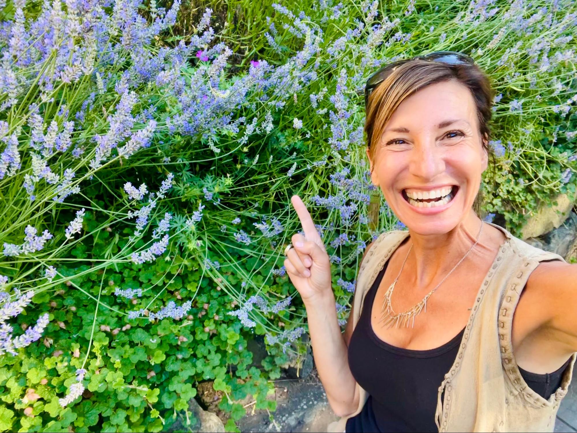 Nicole Apelian pointing at lavender flowers