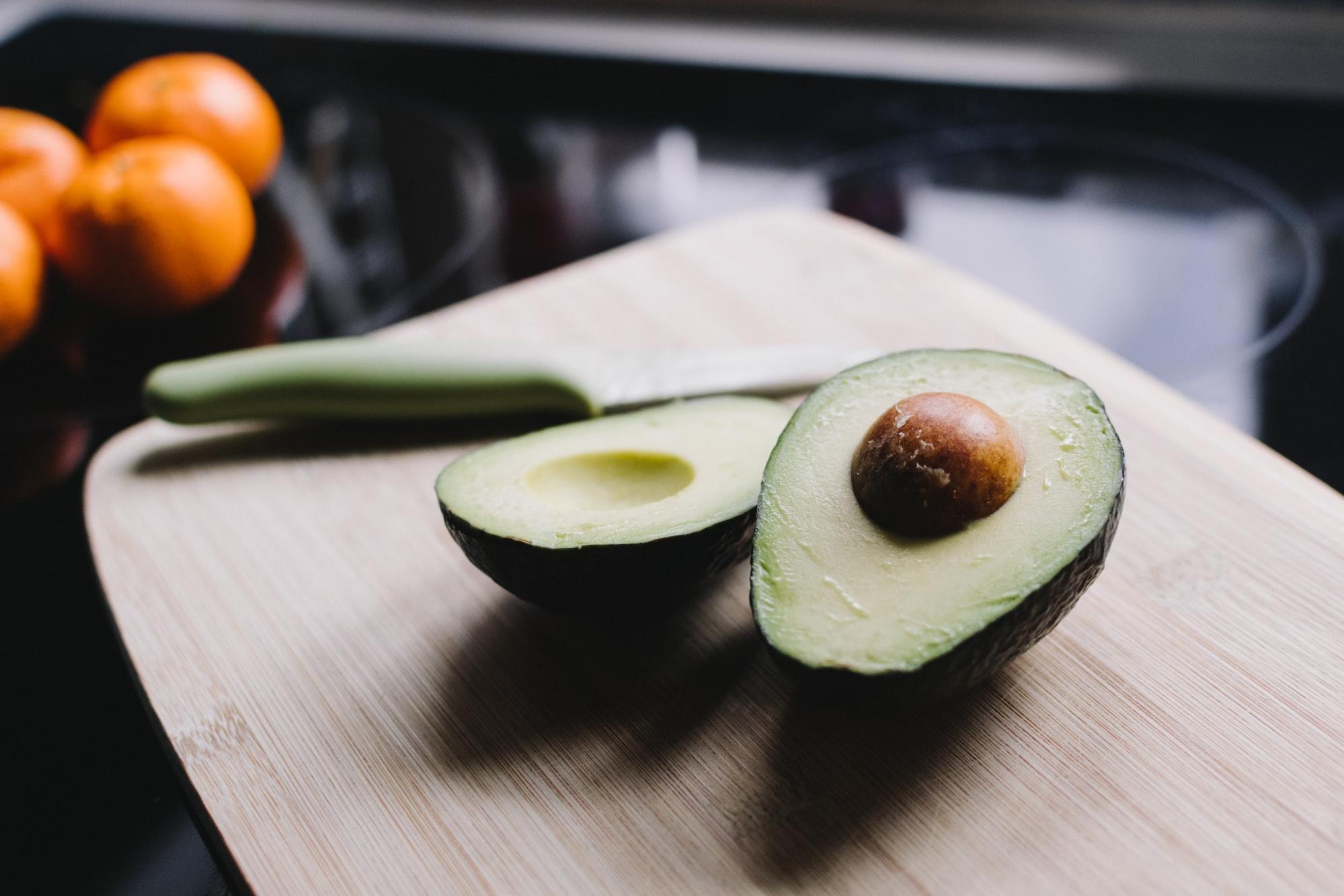 avocado sliced in half on a cutting board