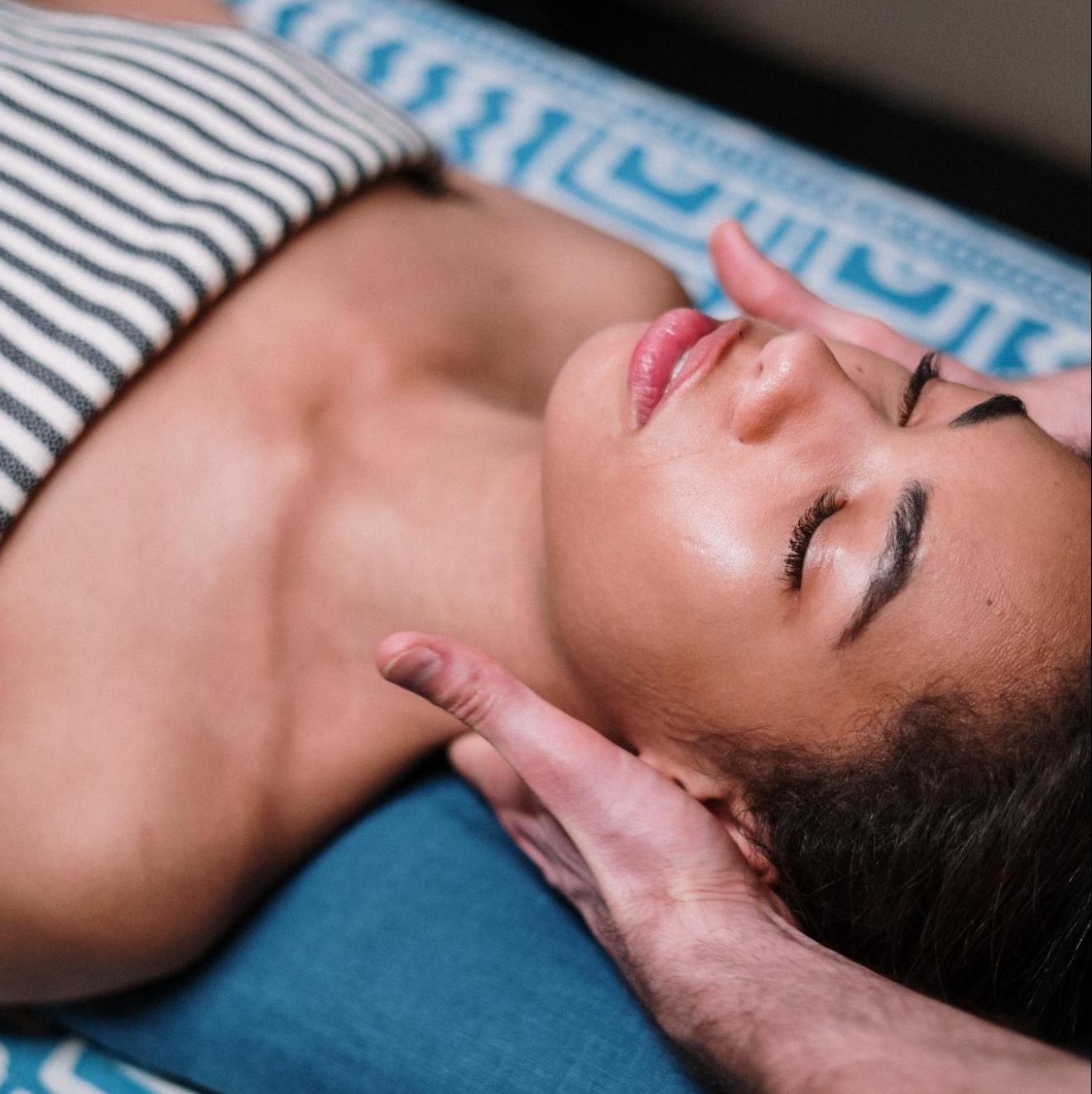woman with eyes closed on table getting massage