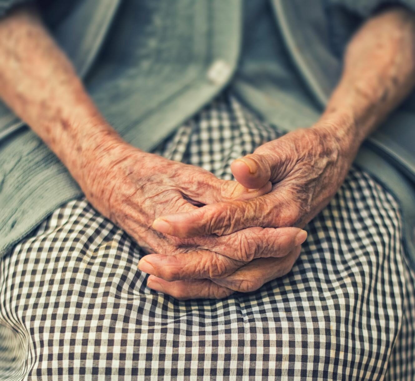 elderly woman with hands in lap