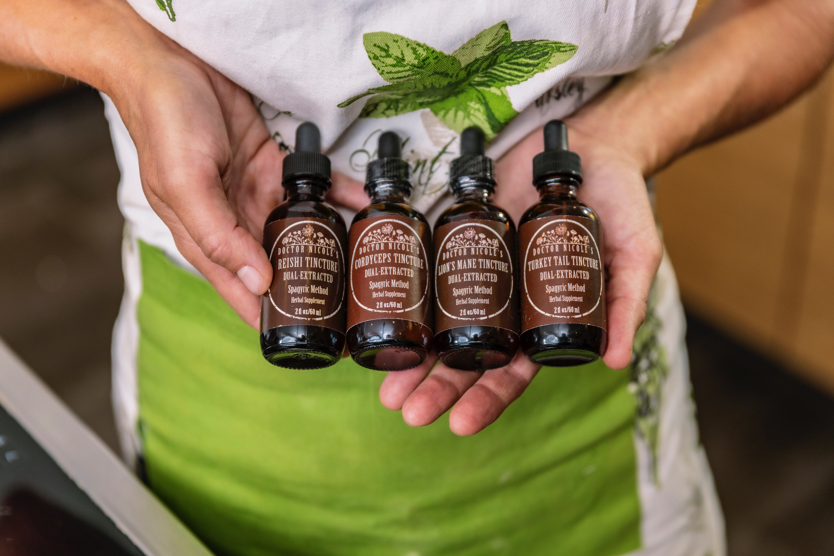 Nicole Apelian holding Mushroom Fourtress tinctures