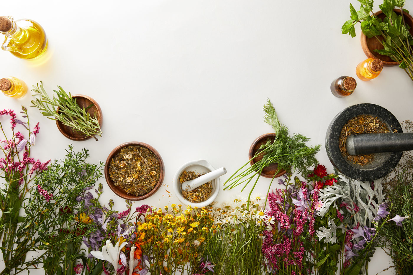 bunches of herbs with mortar and pestles