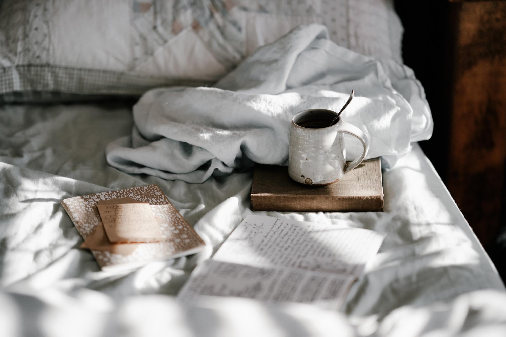 tea and journals on bed
