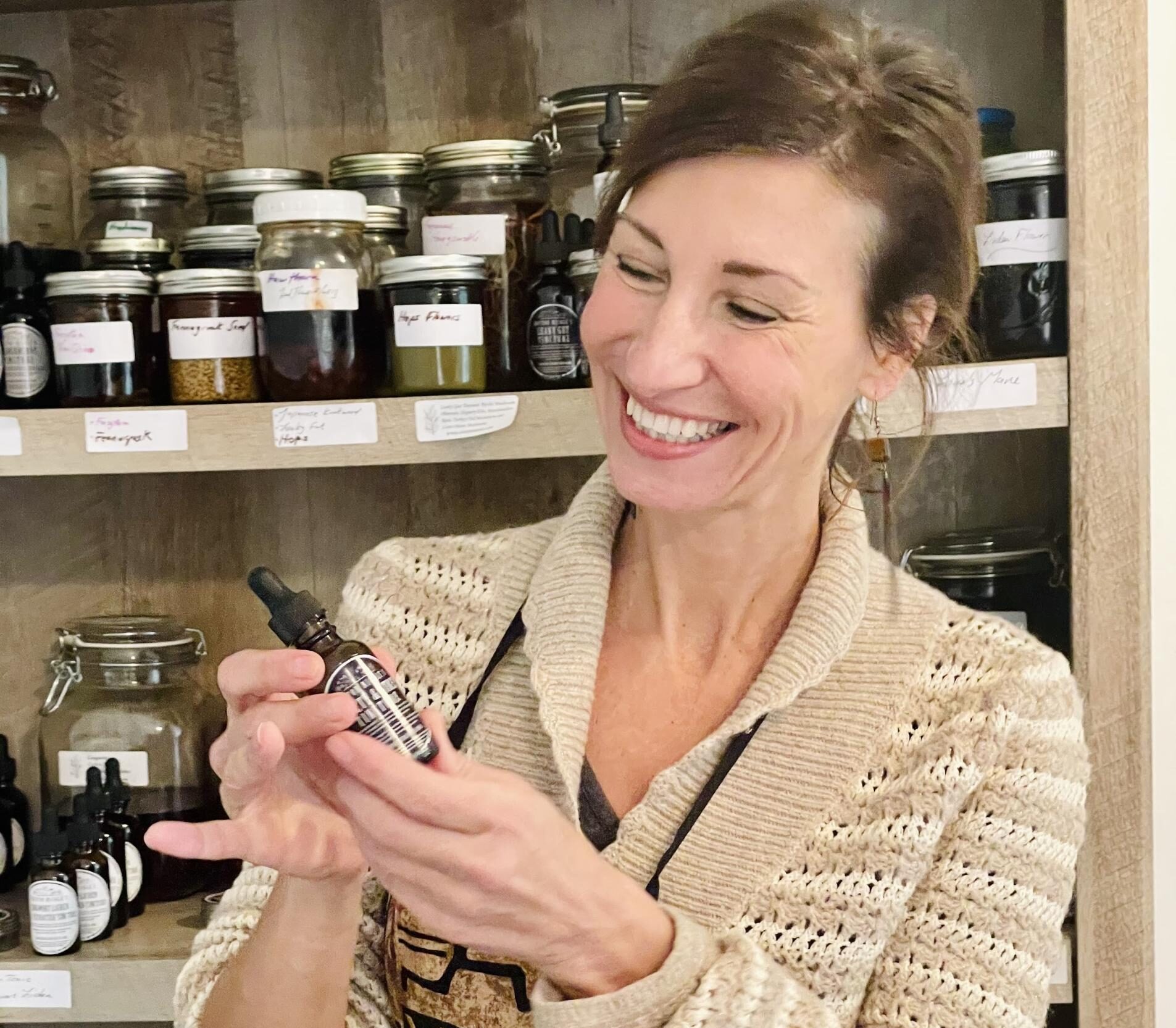 Nicole Apelian holding a tincture from Apothecary