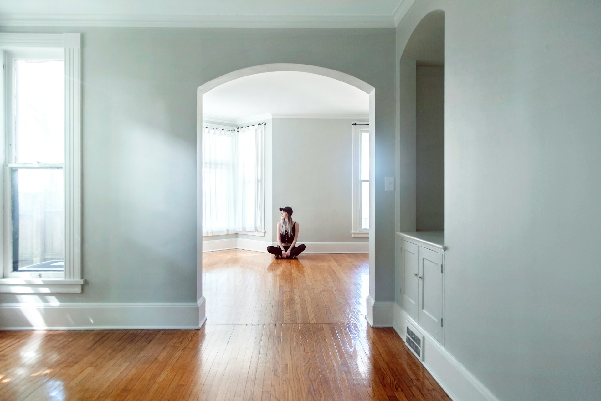 woman sitting on the floor in empty house