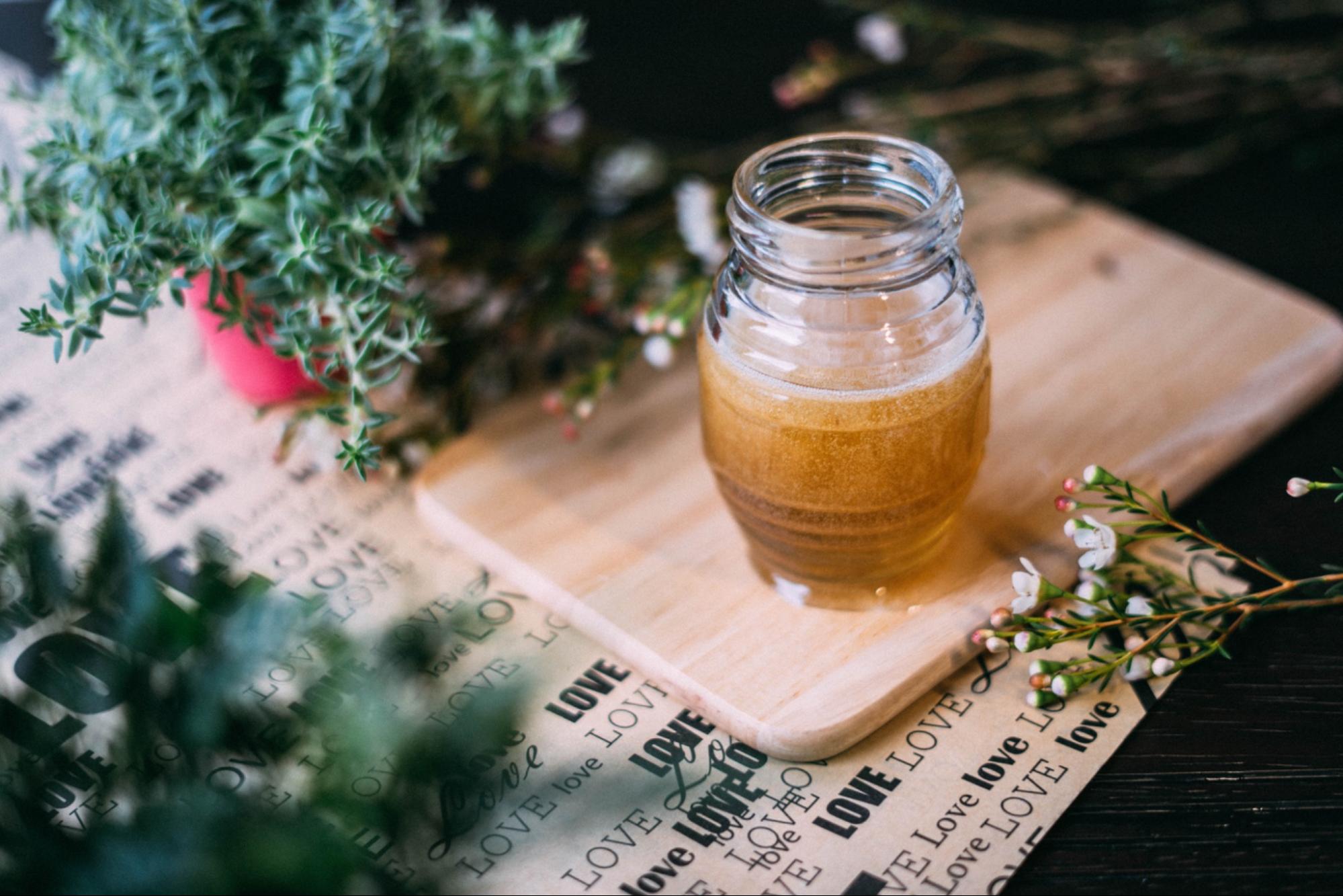 jar of honey on table with botanicals