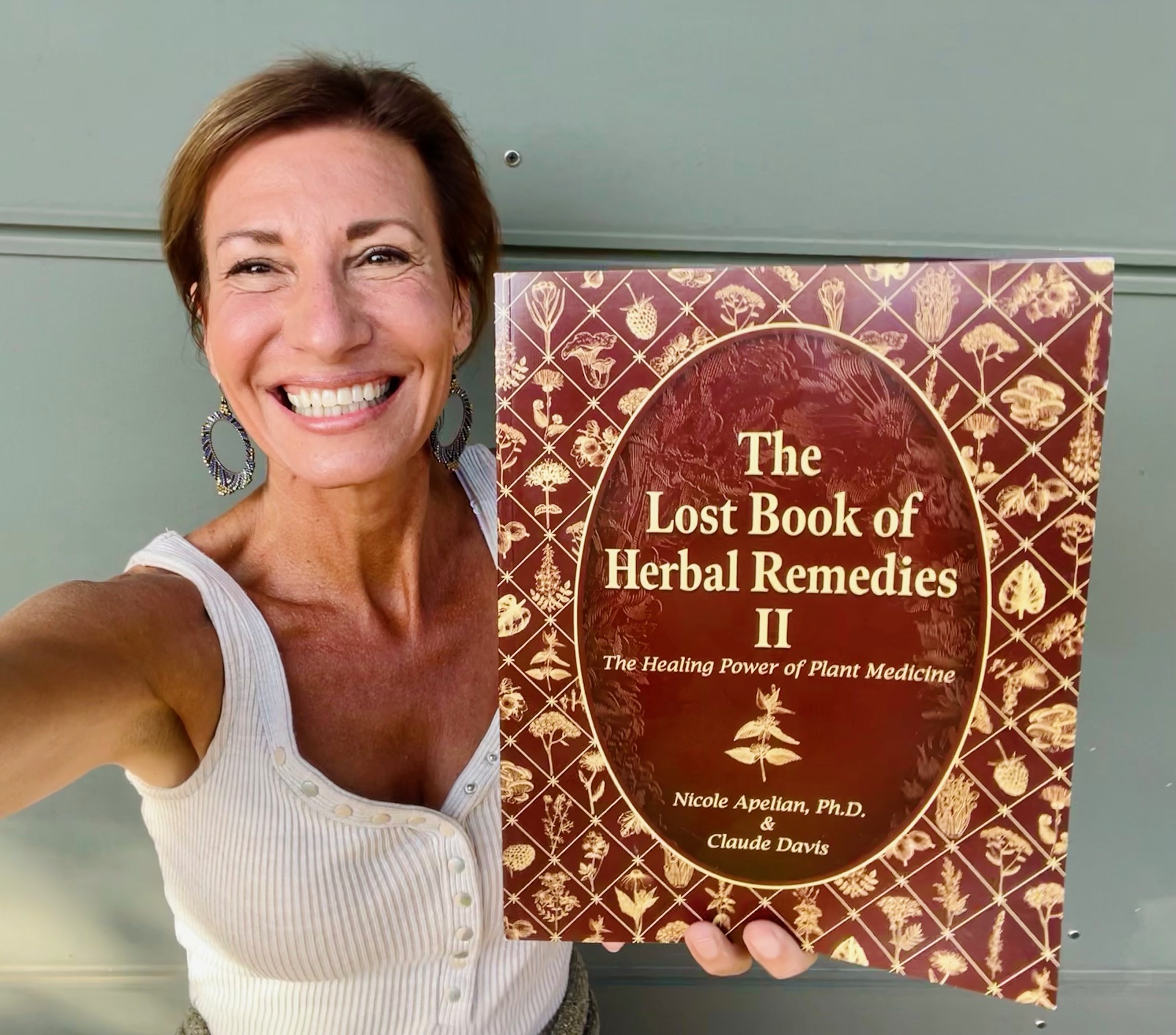 Nicole Apelian holding The Lost Book of Herbal Remedies Volume II