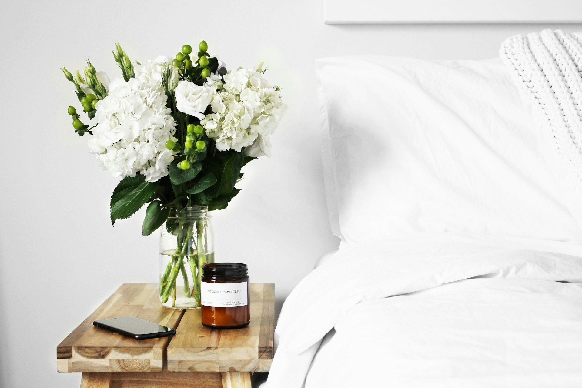 bedside table with flowers and candle