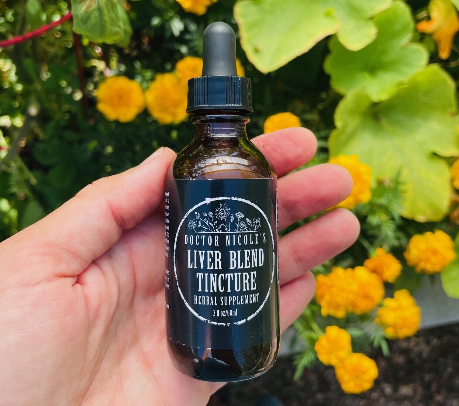 hand holding Liver Blend tincture hand holding Liver Blend tincture