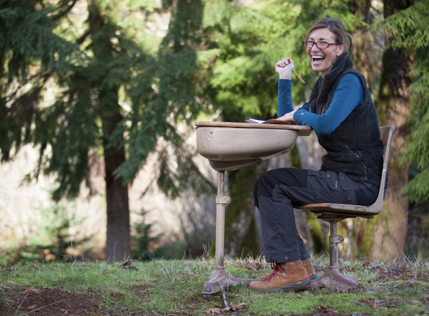 Nicole Apelian sitting at school desk in the forest