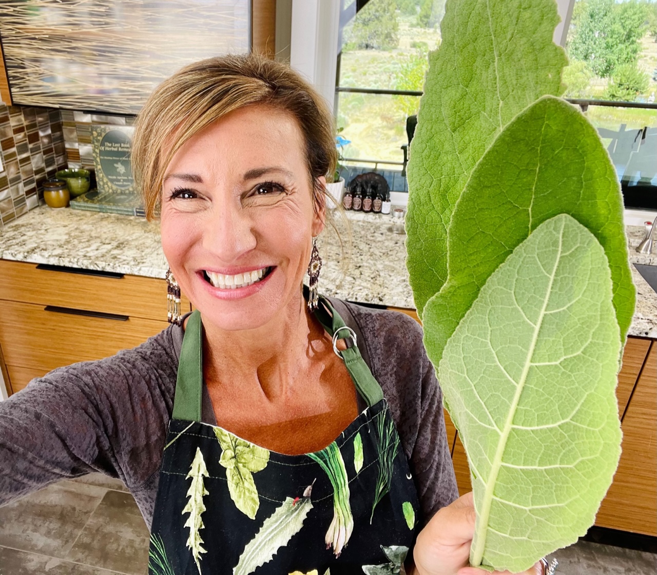 Nicole Apelian holding up fresh mullein leaves in kitchen