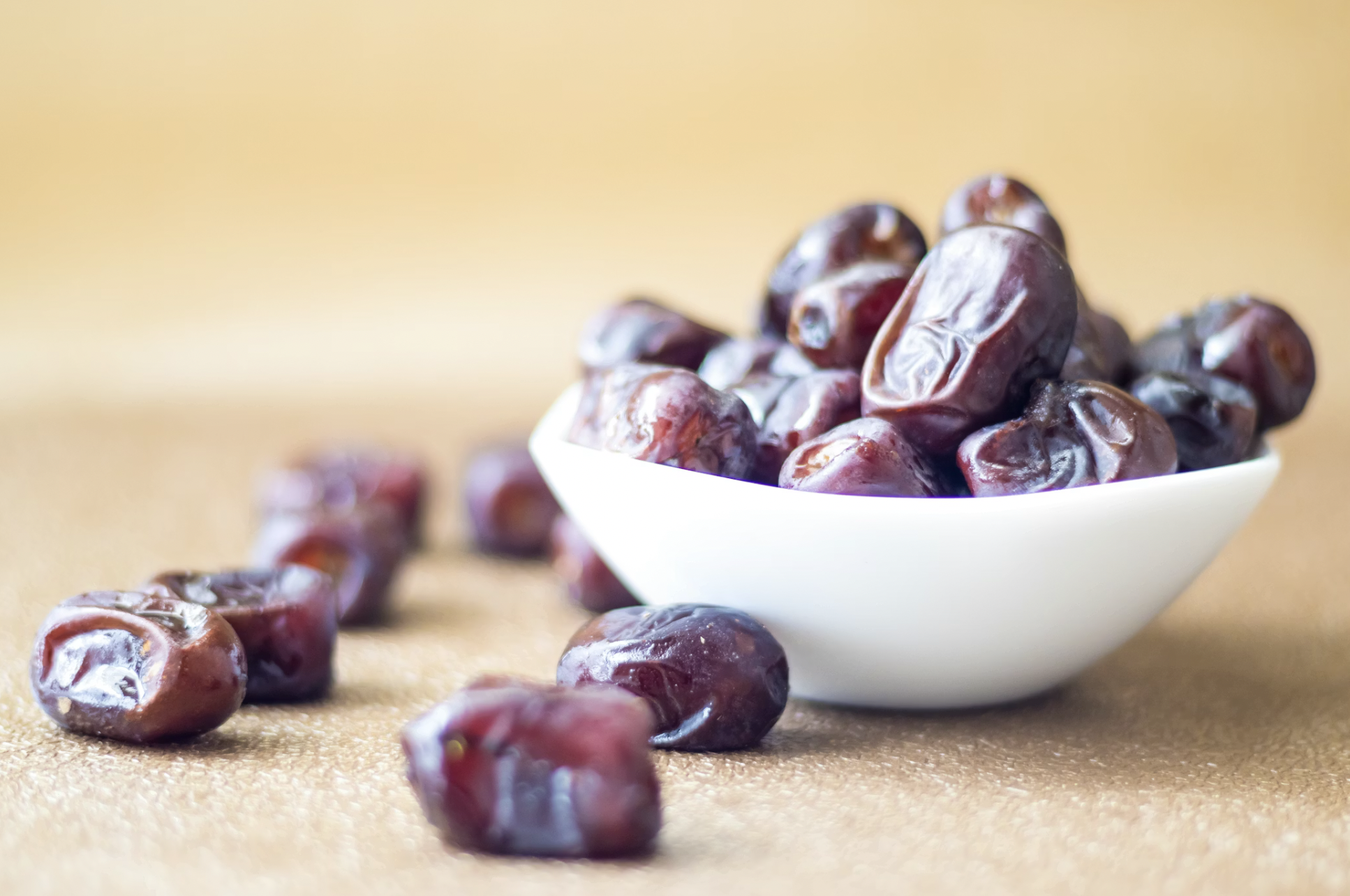 white bowl of dried dates on tabletop